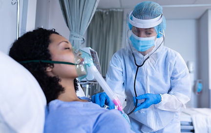 caucasian-doctor-ppe-suit-examining-with-stethoscope-female-patient-with-oxygen-ventilator