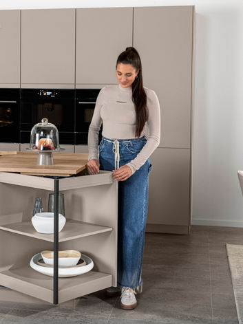 A luxury open-plan German-engineered kitchen display in a bespoke showroom, featuring a large central island and light oak cabinetry, designed by KV Designs in Leeds.