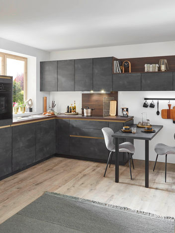 Bespoke modern dark grey fitted kitchen featuring integrated appliances, wood-grain accents, and a compact dining area, professionally crafted by KV Designs in Leeds.