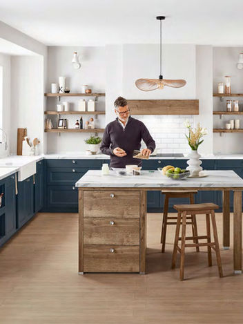 Modern bespoke shaker-style kitchen in navy blue with a rustic wooden island, marble worktops, and open shelving, designed and installed by KV Designs in Leeds.