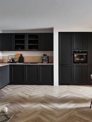 Contemporary premium black shaker-style fitted kitchen with integrated appliances and glass-fronted cabinetry, designed and installed by KV Designs in Leeds.