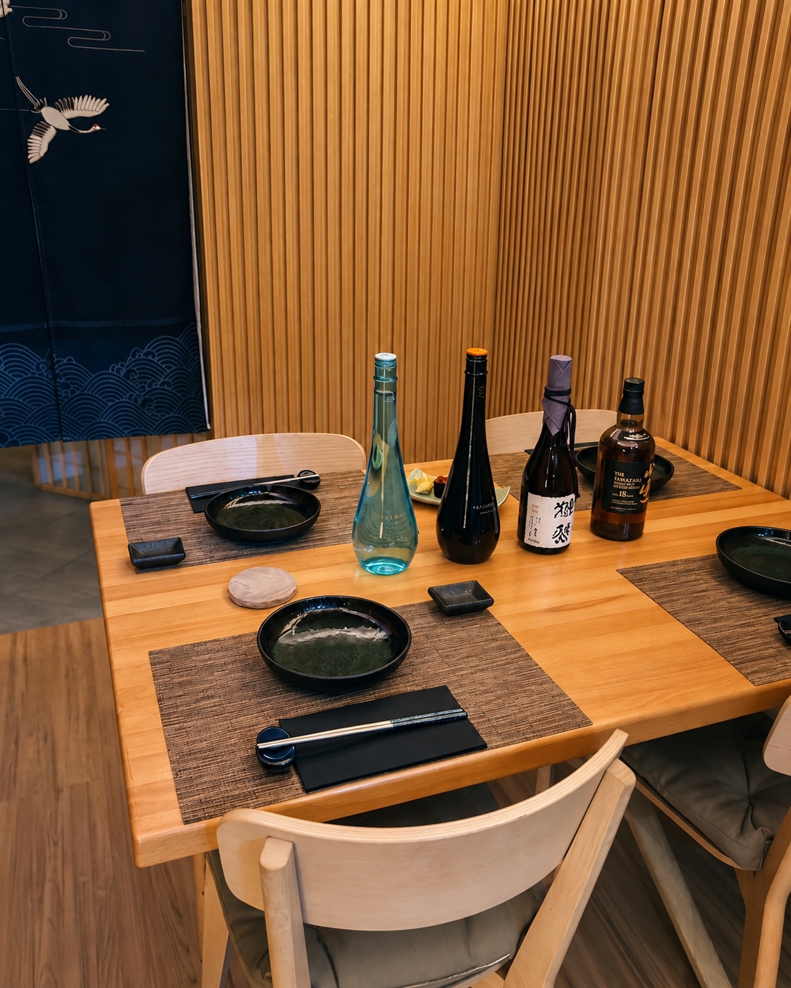 Toyosu’s private omakase room, with warm wood walls and a table set for guests