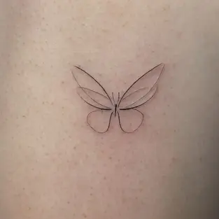 Minimal fine line butterfly tattoo on thigh created in Budva Montenegro with delicate single needle black in lines and minimalist design.