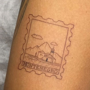 Fine line tattoo of a Montenegro postage stamp design featuring Our Lady of the Rocks and mountains, created at a professional tattoo studio in Budva, Montenegro.