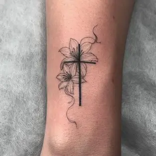 Fine line cross lily flower tattoo on forearm by professional tattoo artist in Budva Montenegro