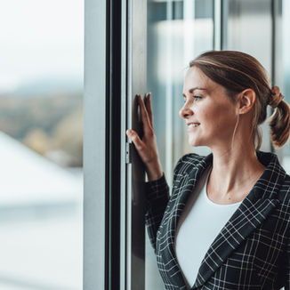 Portrait einer Mitarbeiterin die aus dem Fenster schaut