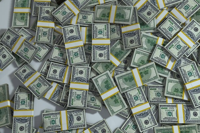 Table covered in bundles of $100 bills with no particular organization.