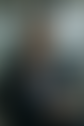 A contemplative executive in a modern office setting, reviewing notes, symbolizing the quiet reflection and internal validation that sustains strong leadership through recognition-sparse periods.