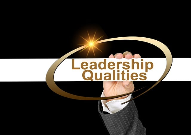 Female executive's hand holding up a sign that says "Leadership Qualities"
