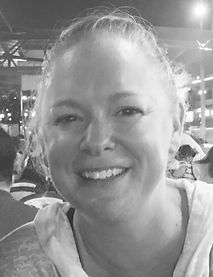 Black and white close-up of a smiling woman with her hair in a messy up-do