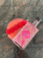 Pink gin cocktail with a miniature of raspberry gin on top with a raspberry garnish