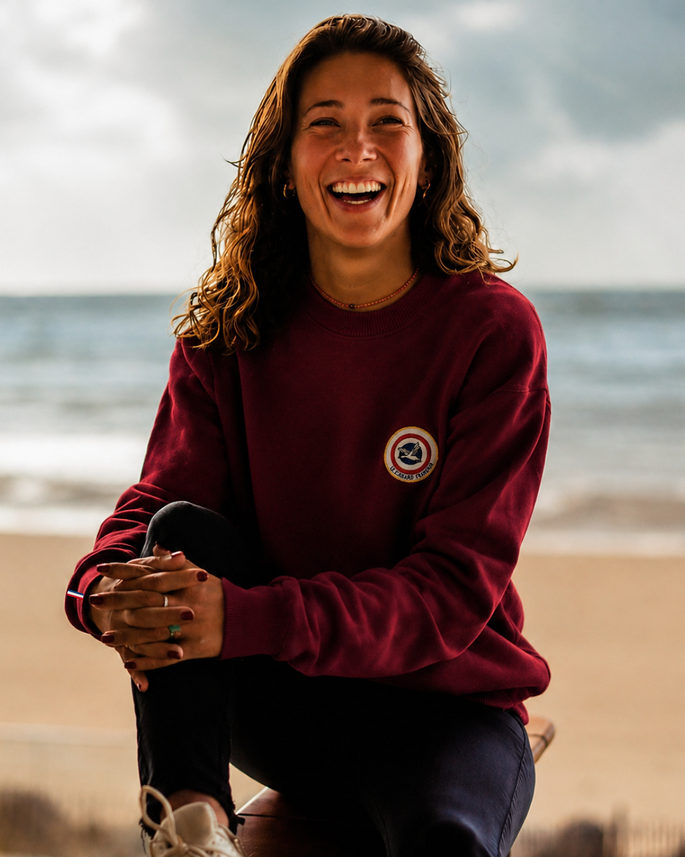 Femme portant le pull bordeaux Le Canard Français sur la plage