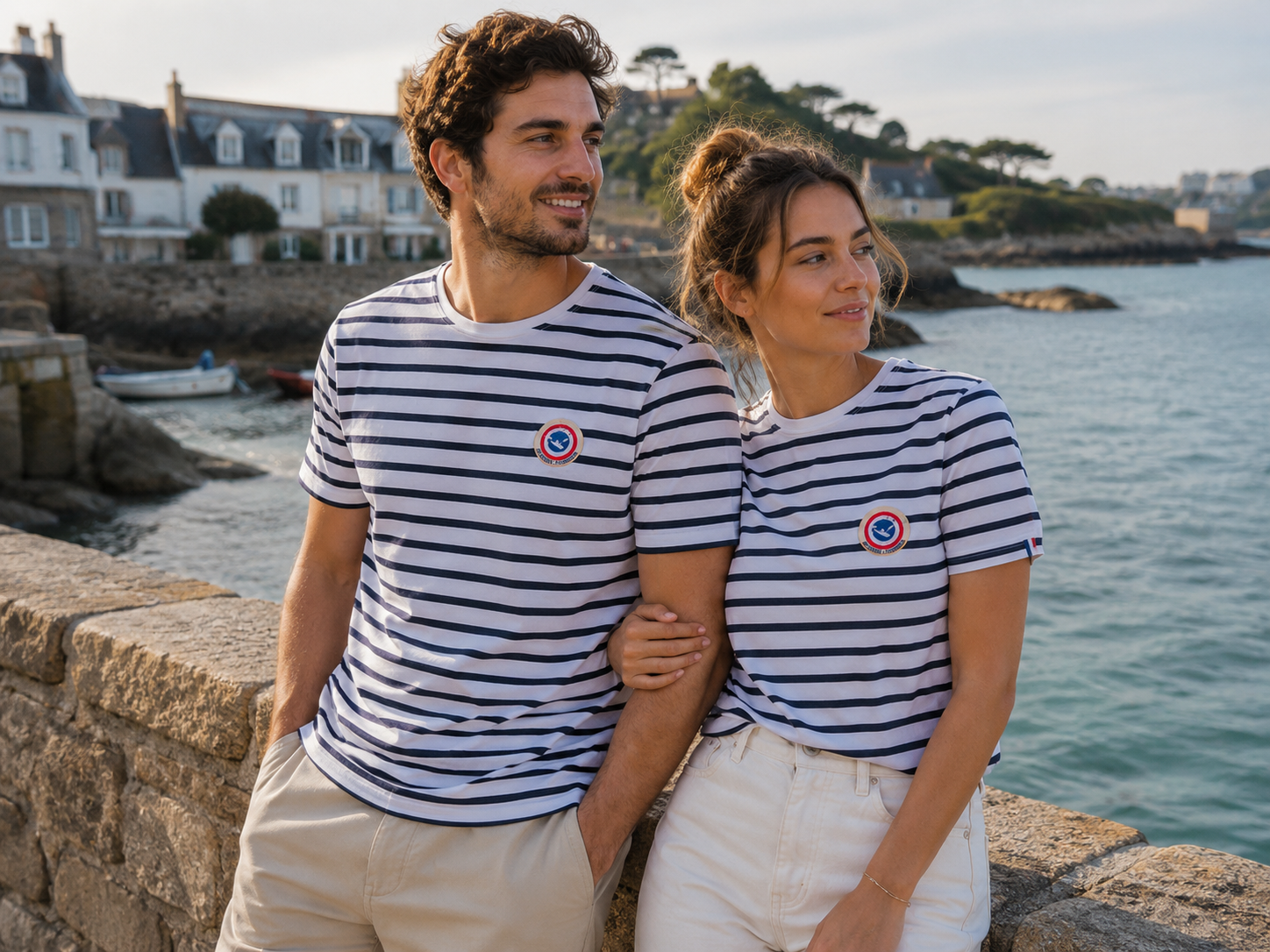 Couple portant un t-shirt marinière Le Canard Français en bord de mer