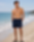Homme portant le short de bain bleu marine Le Canard Français sur la plage
