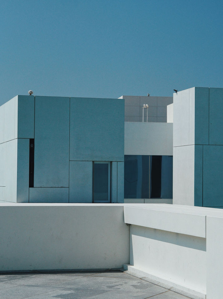 Architectural photography of the Louvre Abu Dhabi in the United Arab Emirates, capturing the iconic dome, geometric patterns, natural light, and the interaction between architecture, space, and visitors.