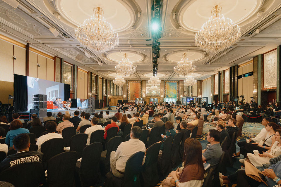 Keynote speaker addressing a large audience at a corporate conference