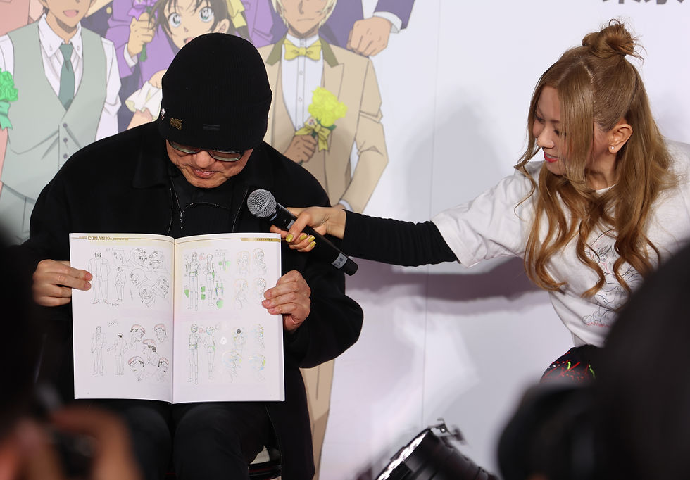 本展覧会のグッズでお気に入りのページを紹介する青木剛昌先生