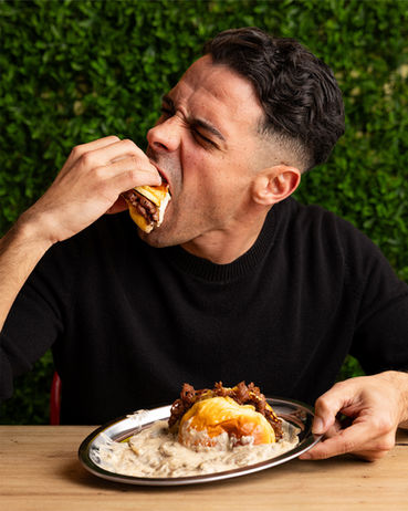 Cliente disfrutando de hamburguesa en restaurante Get Smashed Valdelagrana durante sesión de fotografía gastronómica.