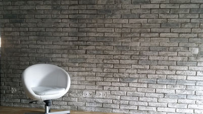 Steinwand in Ziegeloptik als markanter Blickfang im Wohnraum mit strukturierter Natursteinanmutung.