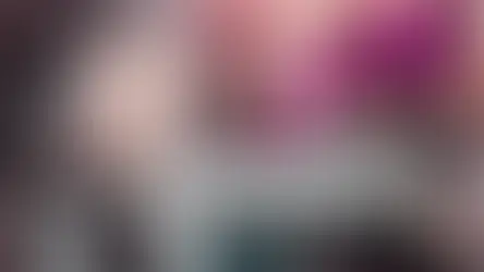 Woman with long gray hair, seated in a colorful room. Text: "6 Signs You Might Be Ready to Stop Colouring Your Hair." Question marks float nearby.