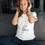 Thumbnail: Woman wearing "baby on board" tee, headphones smiling, seated on couch -- Closer Lives.