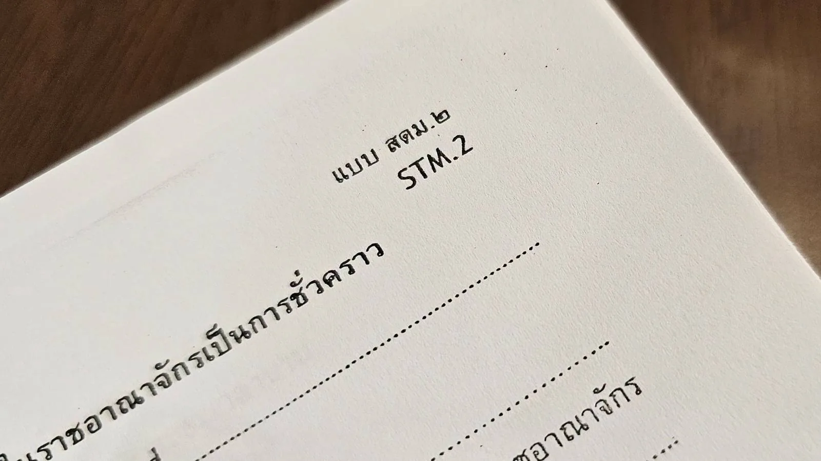 Close-up of a document with Thai text and "STM.2" printed at the top right corner. The image focuses on the upper section of the page, showing a form format.