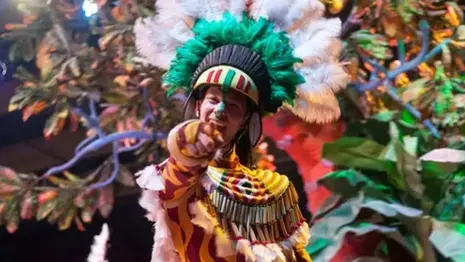 A performer in traditional costume pointing toward the audience during a cultural festival performance in Oceania.