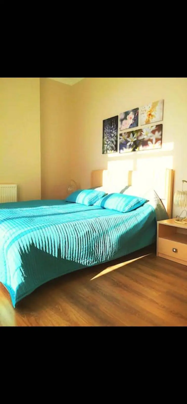 A bedroom with yellow walls and a double bed.