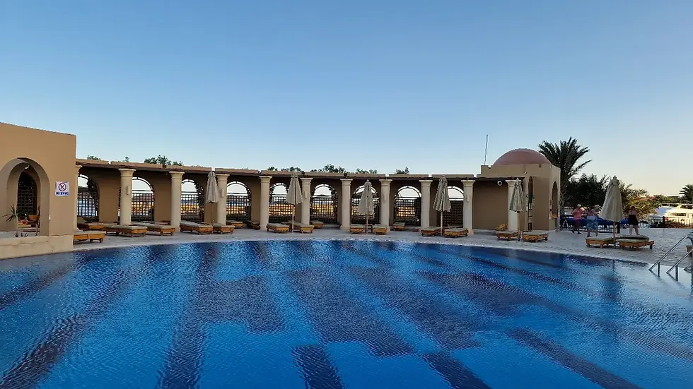 Sunlit pool and loungers with scenic marina views at Three Corners Ocean View Hotel Resort in El Gouna, Egypt.