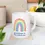 Thumbnail: White mug with rainbow and "gratitude is the attitude" on coaster.