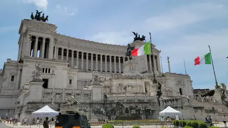Altar of the Fatherland in Rome with Italian flags, marble steps, and statues.