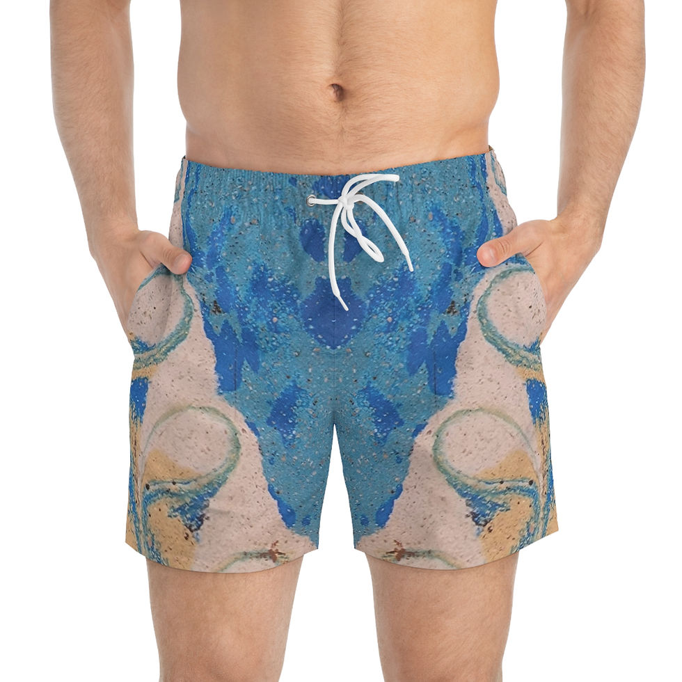 A person wearing blue, beige, and white patterned swim trunks reminiscent of Mexican Tile Art stands with hands in pockets.