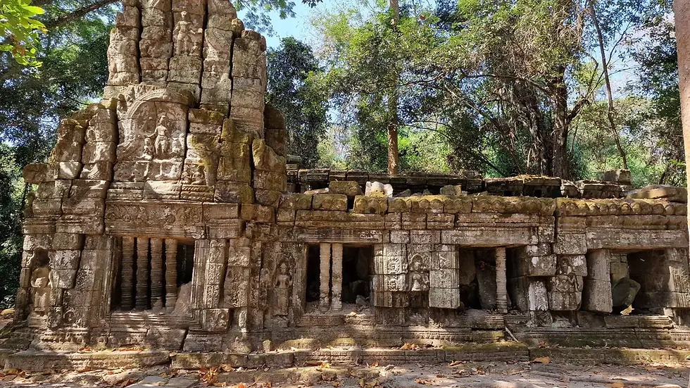 Ancient stone temple with detailed carvings, surrounded by lush trees. Sunlight filters through, creating a serene, historical atmosphere.