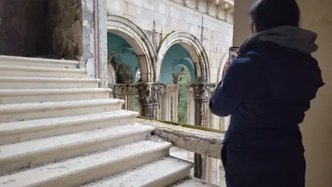 Interior of abandoned Sanatorium Medea with damaged walls, staircases, and faded architectural details.