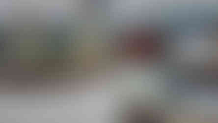 A spacious, well-lit jewelry store with glass display cases filled with various jewelry items, shiny floors, and decorative columns. The store has modern lighting and a luxurious atmosphere.