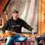 Thumbnail: Man pouring drink from bottle while wearing 'over ruled' hoodie.