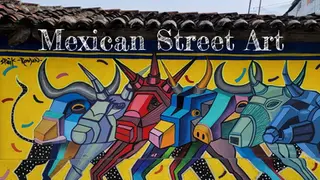 Colorful street art mural of geometric bulls on a yellow background, with "Mexican Street Art" text above. Vibrant and energetic design.