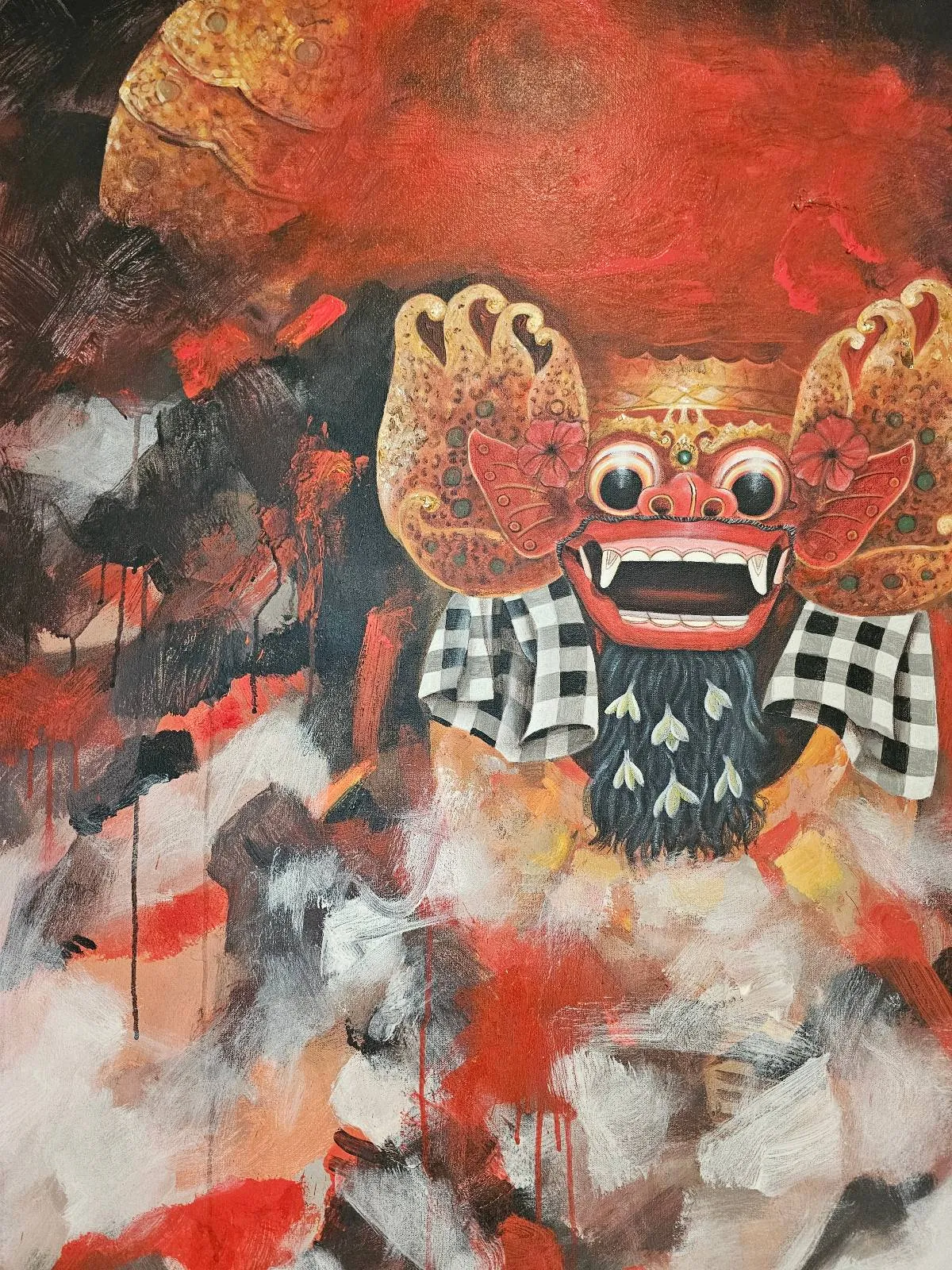 A colorful painting of a traditional Balinese Barong mask with wide eyes, large teeth, and raised hands, set against a vivid red, black, and white smoky background.