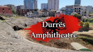 Historic Durrës Amphitheatre with modern buildings in the background. Bright day with a red and black splash displaying its name.