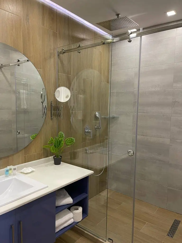 A bathroom with a large shower and floating vanity unit.
