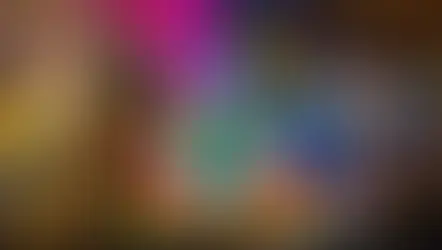 Couple poses in a colorful cave restaurant with Mexican flags. Bar and seating in background. Text: "Alux Restaurant Playa del Carmen."