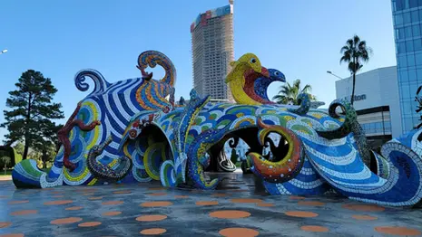 Colorful octopus sculpture in Batumi with mosaic details and surrounding open plaza.