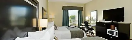 A clean, modern hotel room featuring two beds and dark wood furniture at the Best Western Plus Travel Hotel Toronto Airport in Ontario, Canada.