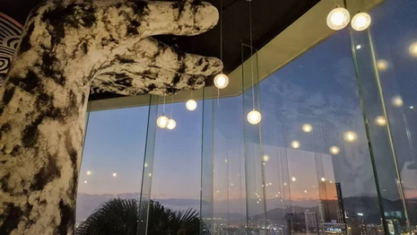 Interior of the top-floor restaurant at SALA Danang Beach Hotel, with dining tables, city views, and modern decor.