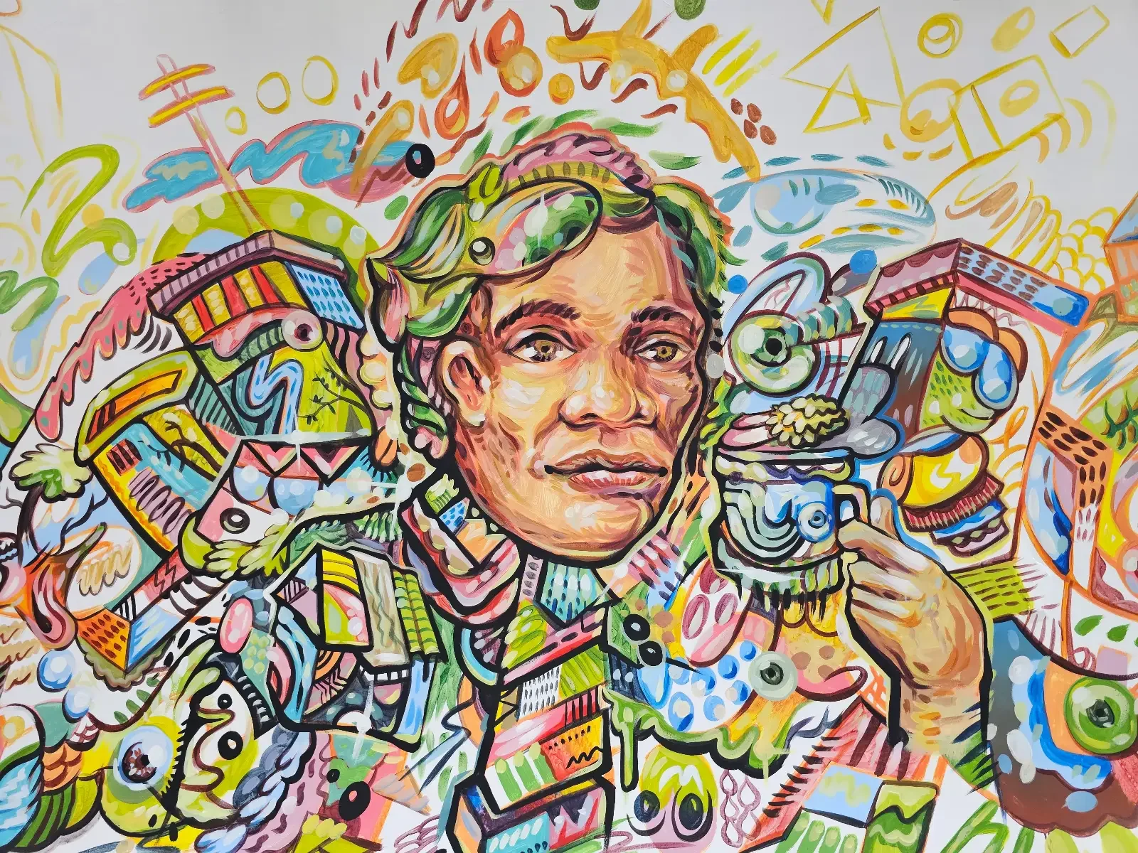 A colorful, abstract painting features a person with goggles surrounded by swirling shapes, faces, patterns, and animals. The figure holds a cup, blending into the lively, imaginative background filled with vivid hues and intricate details.