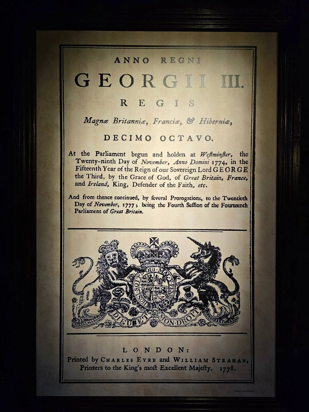 A close-up of a historical document from the reign of King George III, featuring ornate text and a royal coat of arms.