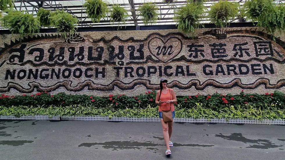 A woman walking in front of a large mural of a tropical garden.