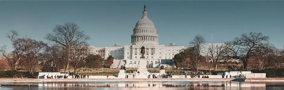 United States Capitol building in Washington, D.C. reflecting in the pool under a clear blue sky during a coast-to-coast American road trip.
