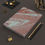 Thumbnail: A Brushed Pink Marble Journal rests elegantly on a textured surface, surrounded by gold and black pencils.