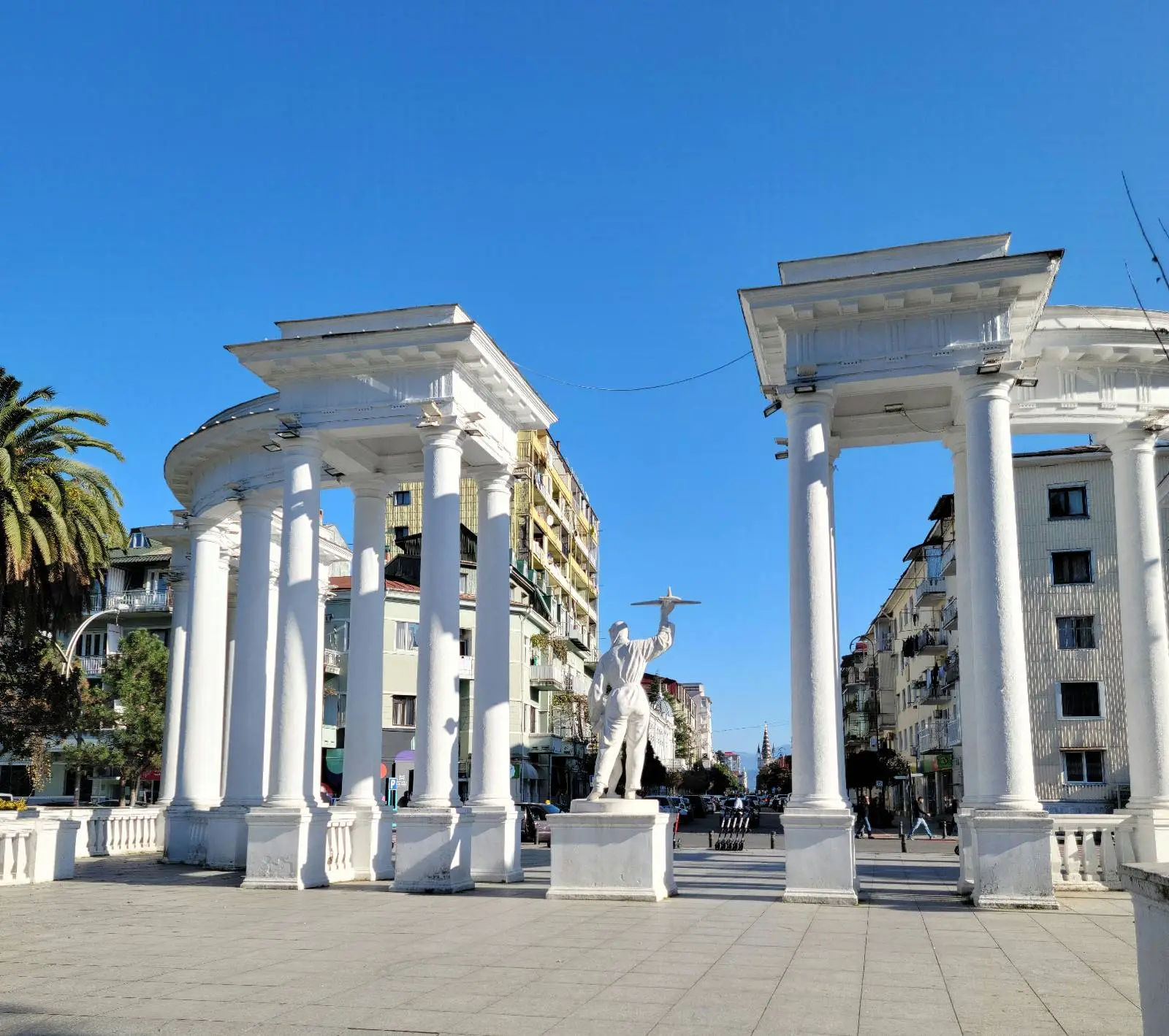 Tall white pillar monument with central figure statue.